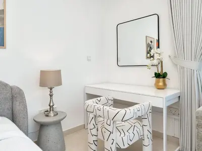 a bedroom with a white desk and a chair at Kensington-2BR Huge & Central at Executive Tower in Dubai
