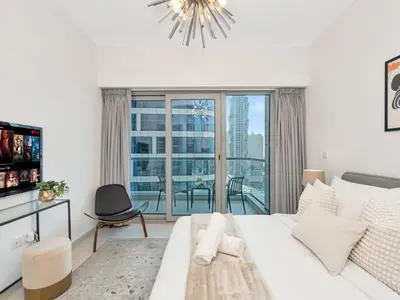 a bedroom with a white bed and a large window at Kensington-2BR Huge & Central at Executive Tower in Dubai
