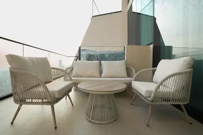 a balcony with chairs and a table and a couch at The Royale Blue Luxury Suite 325 Private Plunge Pool in Dubai