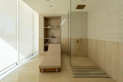 a bathroom with a bench and a glass shower at The Royale Blue Luxury Suite 325 Private Plunge Pool in Dubai