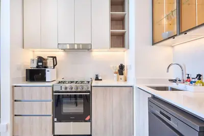 a kitchen with a stove and a sink at Luxury 1BR Apartment Steps from Dubai Hills Mall in Dubai