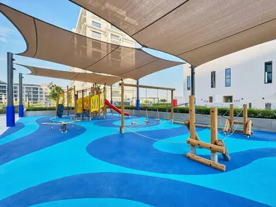 a playground with a slide and swings at Luxury 1BR Apartment Steps from Dubai Hills Mall in Dubai