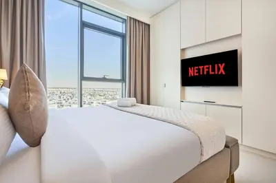 a bedroom with a white bed and a window at Luxury 1BR Apartment Steps from Dubai Hills Mall in Dubai