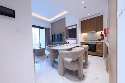 a kitchen with a table and chairs in a room at Modern 2BR Retreat Azizi Riviera 61 Square in Dubai