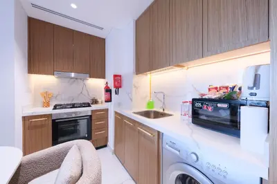 a kitchen with a washer and a sink and a stove at Modern 2BR Retreat Azizi Riviera 61 Square in Dubai