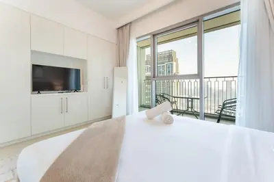 a white bedroom with a large bed and a large window at Stylish 2BHK with Burj Khalifa Views in Downtown in Dubai