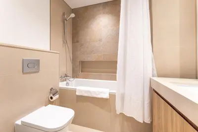 a bathroom with a toilet and a tub and a sink at Stylish 2BHK with Burj Khalifa Views in Downtown in Dubai