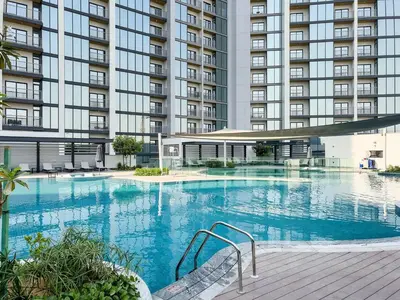 a large swimming pool in front of a large building at Chic 1BR Retreat Sobha Crest with Pool & Gym in Dubai