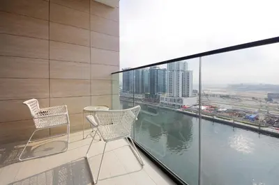 a balcony with two chairs and a view of a city at Wecation - Cozy Studio , Trillionaire , Private Jacuzzi in Dubai