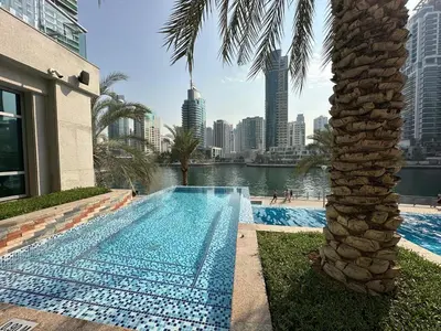 a swimming pool with a palm tree and a city at sanibel tower in Dubai