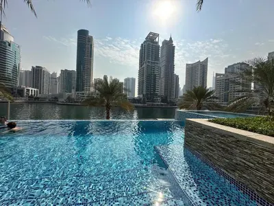 a swimming pool with a city skyline in the background at sanibel tower in Dubai
