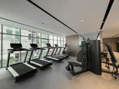 a gym with a row of treadmills and machines at Vogue Business Bay Royal Regency near Downtown, Burj Khalifa and Dubai Mall, One Bedroom Apartment with Balcony and partial Burj Khalifa view, Access to all Amenities in Dubai