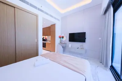 a white room with a bed and a television at Modern Studio Azizi Riviera 59 Al Merkadh Community in Dubai