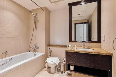a bathroom with a tub and a toilet and a sink at Downtown View 2BHK in Dubai