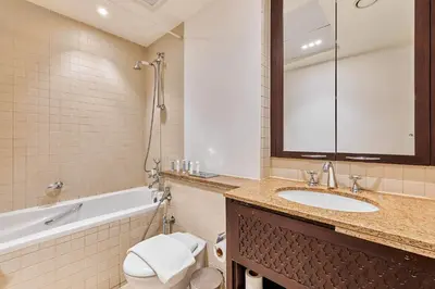 a bathroom with a sink and a toilet and a tub at Downtown View 2BHK in Dubai