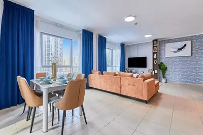 a living room with a couch and a table with chairs at Downtown View 2BHK in Dubai