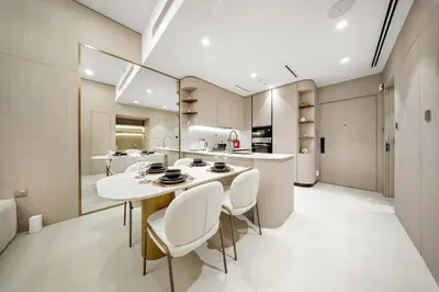 a kitchen and dining room with a white table and chairs at Spacious 1BR in JVC with Lounge Access in Dubai