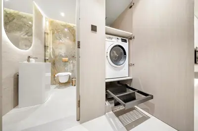 a bathroom with a washer and dryer in it at Spacious 1BR in JVC with Lounge Access in Dubai