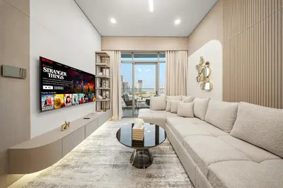 a living room with a white couch and a tv at Spacious 1BR in JVC with Lounge Access in Dubai