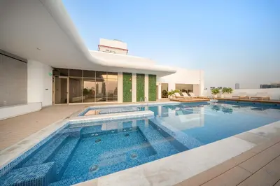 a large swimming pool in front of a house at Spacious 1BR in JVC with Lounge Access in Dubai