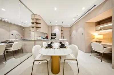 a kitchen and dining room with a white table and chairs at Spacious 1BR in JVC with Pool and Gym Access in Dubai