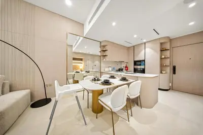 a kitchen and living room with a table and chairs at Spacious 1BR in JVC with Pool and Gym Access in Dubai