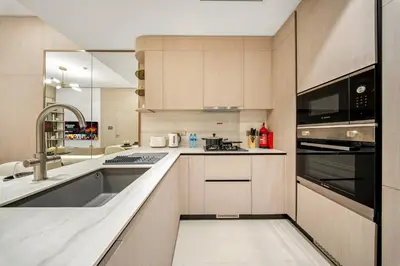 a kitchen with wooden cabinets and a sink at Spacious 1BR in JVC with Pool and Gym Access in Dubai