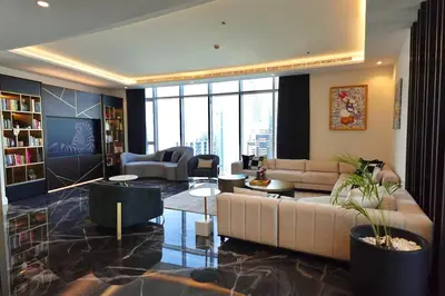 a living room with a large couch and a large window at Iconic Triplex Penthouse in Marina in Dubai