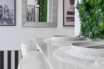 a dining table with two white plates and a plant at The Address JBR, Address Beach Resort, Marina View - Onelink in Dubai