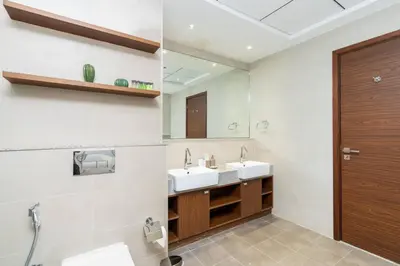 a bathroom with two sinks and a wooden door at CitiHome - Spacious 2BR - Park Gate Residences in Dubai