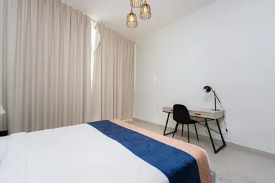 a bedroom with a bed and a desk and a chair at CitiHome - Spacious 2BR - Park Gate Residences in Dubai