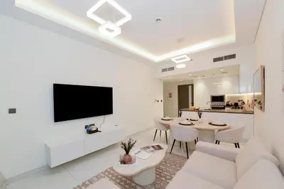a white living room with a table and a tv at Luxury 2BR with Private Pool Balcony Arjan in Dubai
