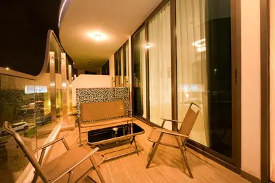 a balcony with chairs and a table and a window at Luxury 2BR with Private Pool Balcony Arjan in Dubai