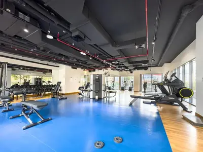 a gym with a blue gym floor with treadmills at Elegant 1BR in Bellevue Towers Downtown Dubai in Dubai