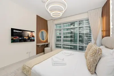 a bedroom with a white bed and a window at Luxury Apt in Lofts Downtown, Walk to Dubai Mall, Burj Khalifa, Gym, Pool, 500mbps Wifi in Dubai