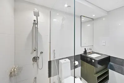 a bathroom with a shower and a toilet and a sink at Luxury Apt in Lofts Downtown, Walk to Dubai Mall, Burj Khalifa, Gym, Pool, 500mbps Wifi in Dubai