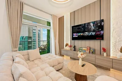 a living room with a large couch and a flat screen tv at Luxury Apt in Lofts Downtown, Walk to Dubai Mall, Burj Khalifa, Gym, Pool, 500mbps Wifi in Dubai