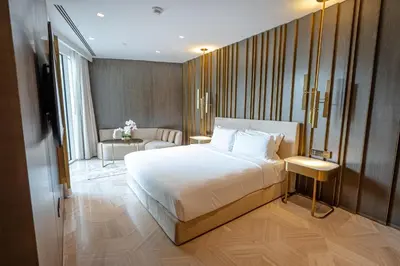 a bedroom with a large bed and a living room at Daniels Spacious 3BR with Maid at Five Palm Jumeirah in Dubai