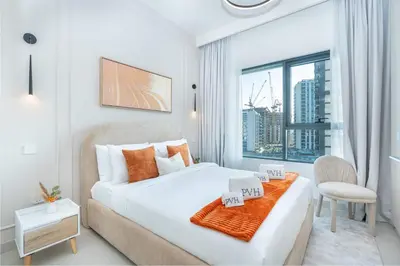 a white bedroom with a large bed and a window at PVH - Chic Pool View 2BR Near Dubai Hills Park - Park Field Tower 2 in Dubai