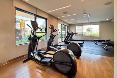 a gym with three tread machines in a room at PVH - Chic Pool View 2BR Near Dubai Hills Park - Park Field Tower 2 in Dubai