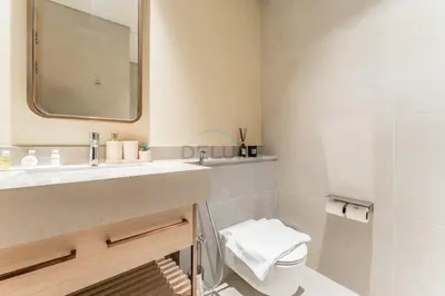 a bathroom with a sink and a toilet and a mirror at Direct Walking Access to Dubai Mall and Burj Khalifa with Metro Connectivity to Prime Attractions - Vida Dubai Mall Tower 2, Downtown Dubai by Deluxe Holiday Homes in Dubai