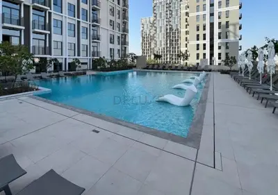 a swimming pool in a city with tall buildings at Steps from Dubai Hills Mall, Near Scenic Park, and Easily Connected to Dubai Top Attractions - Socio Tower 1, Dubai Hills by Deluxe Holiday Homes in Dubai