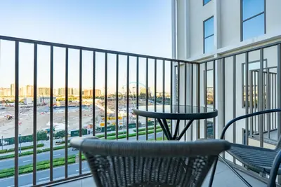 a balcony with a table and chairs on a building at Steps from Dubai Hills Mall, Near Scenic Park, and Easily Connected to Dubai Top Attractions - Socio Tower 1, Dubai Hills by Deluxe Holiday Homes in Dubai