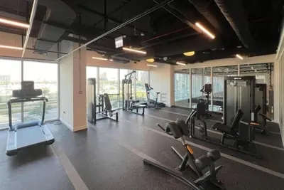 a gym with treadmills and cardio equipment in a building at Steps from Dubai Hills Mall, Near Scenic Park, and Easily Connected to Dubai Top Attractions - Socio Tower 1, Dubai Hills by Deluxe Holiday Homes in Dubai