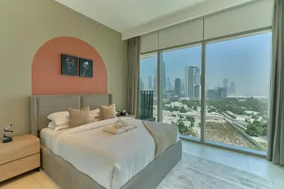 a bedroom with a large bed and a large window at Stylish 4BR with Burj View and Dubai Mall Connection in Dubai
