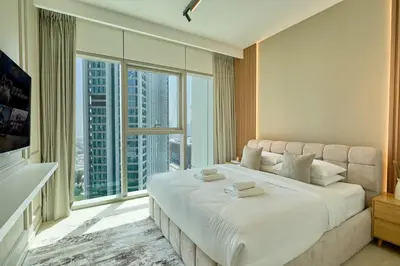 a bedroom with a large bed and a large window at Stylish 4BR with Burj View and Dubai Mall Connection in Dubai