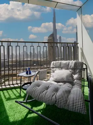 a chair and a table on a balcony with a view at Stylish 4BR with Burj View and Dubai Mall Connection in Dubai
