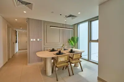 a kitchen with a table and chairs in a room with windows at Stylish 4BR with Burj View and Dubai Mall Connection in Dubai