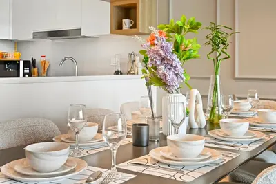 a dining room table with plates and glasses and flowers at 3bd apartment in downtown dubai in Dubai