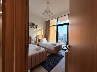 a hotel room with two beds and a window at Modern 2BR with Balcony in Azizi Riviera 23 in Dubai